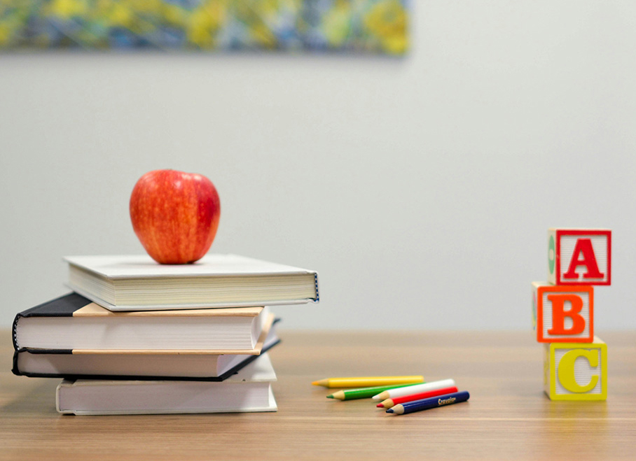 teacher's desk with books, blocks, and an apple